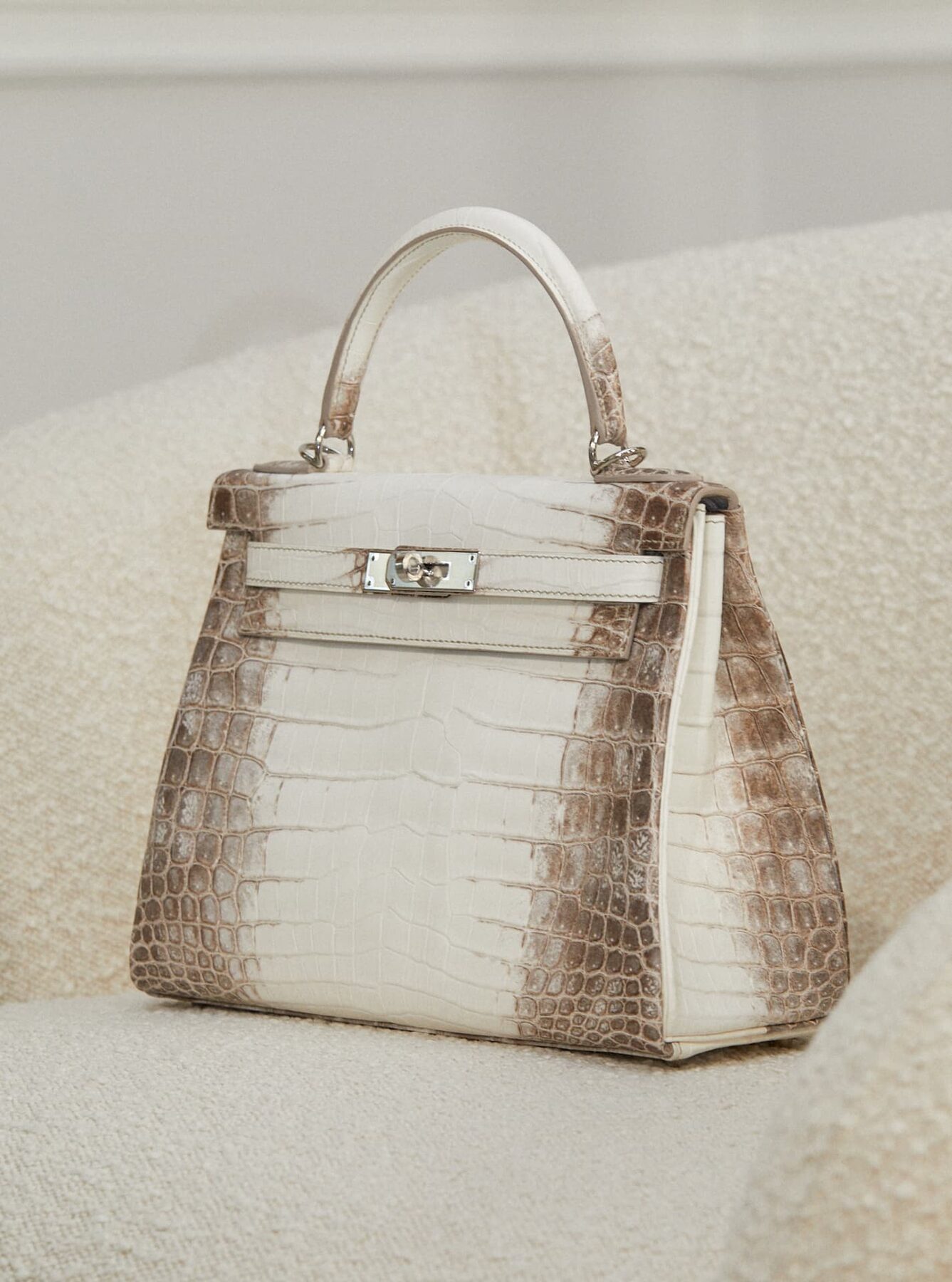 A Himalaya crocodile Hermès Kelly on a bouclé chair