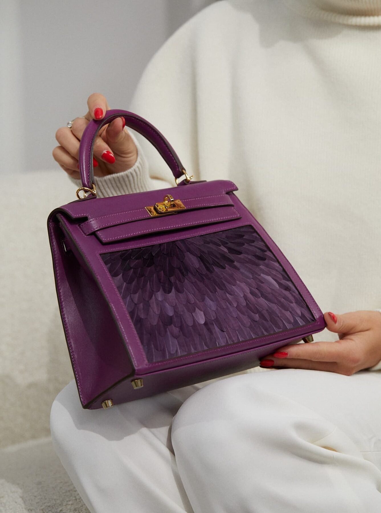 A purple Hermès Kelly held by a collector