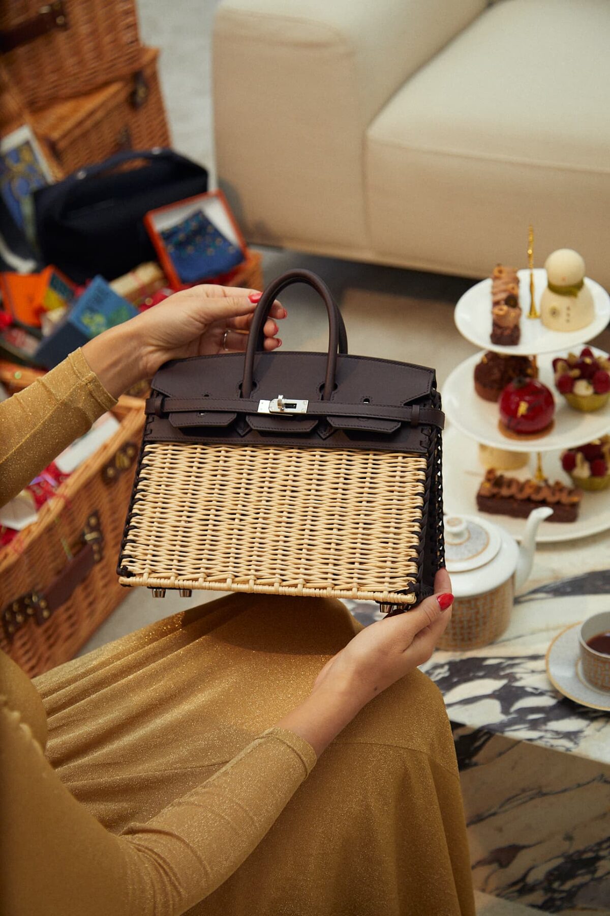 A wicker and leather Hermès Kelly beside a tea service